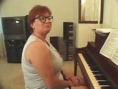 Plump piano teacher busted getting skewered with a pair of purple poles