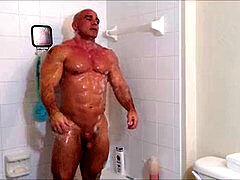 Soapy and oily shower with a muscular man