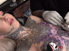 Sascha plays with Amber Luke while she gets tattooed